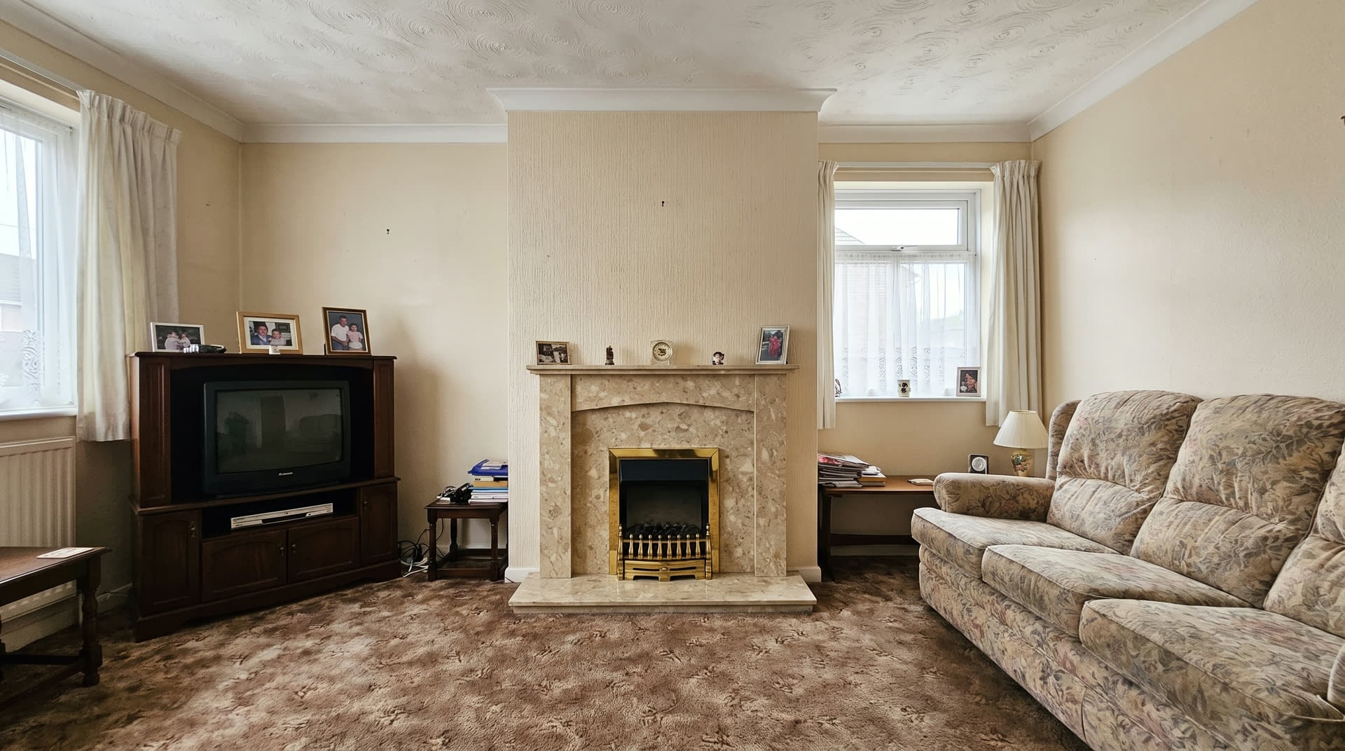 Before — a dated marble-effect surround and brass gas fire